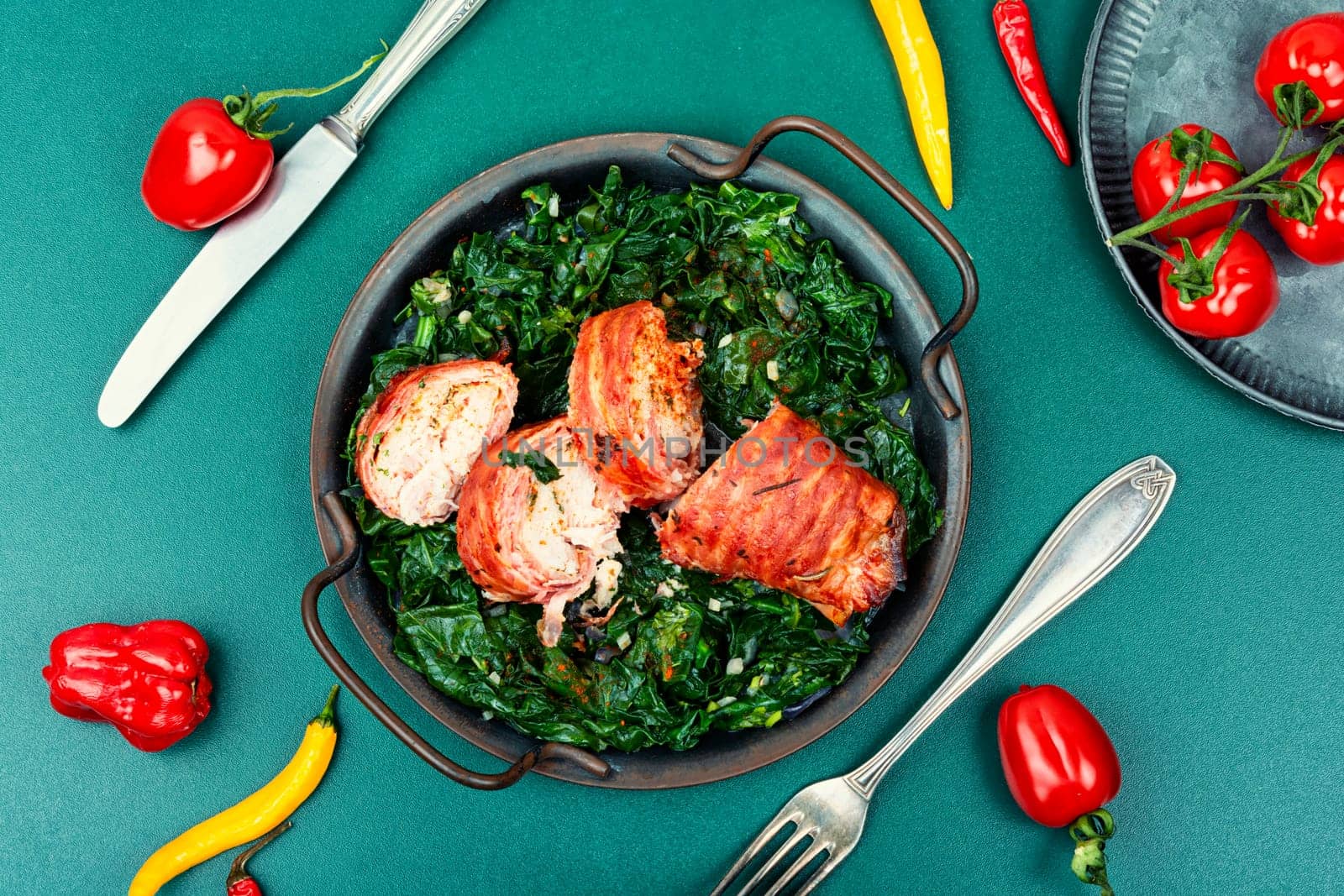 Baked chicken roll with fried spinach leaves. Space for text