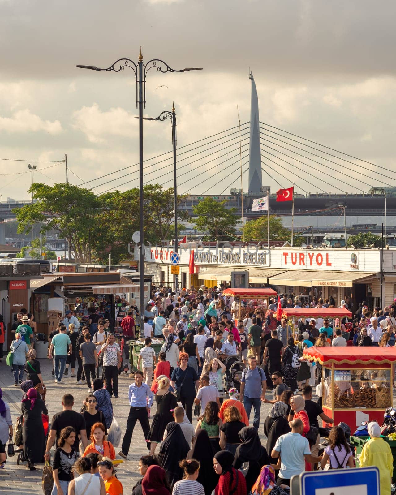 Istanbul, Turkey - August 30, 2022: Crowds of local citizens at Eminonu Plaza during the Victory Day holiday with background of Istanbul city view including Golden Horn Metro Bridge