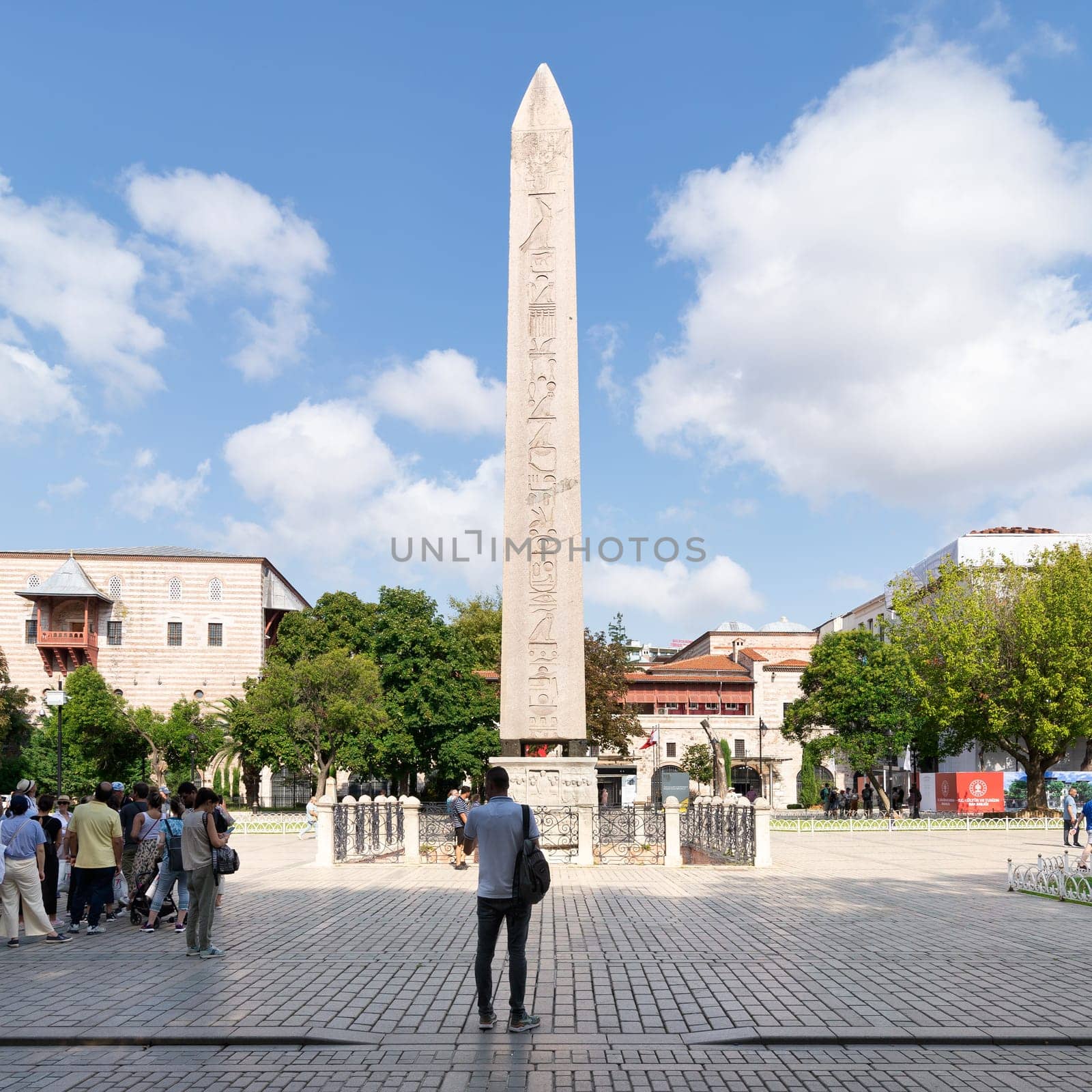 Istanbul, Turkey - August 30 2022: Tourists visiting the Obelisk of Theodosius, ancient Egyptian obelisk of Pharaoh Thutmose III re-erected in the Hippodrome of Constantinople, or Sultanahmet Square