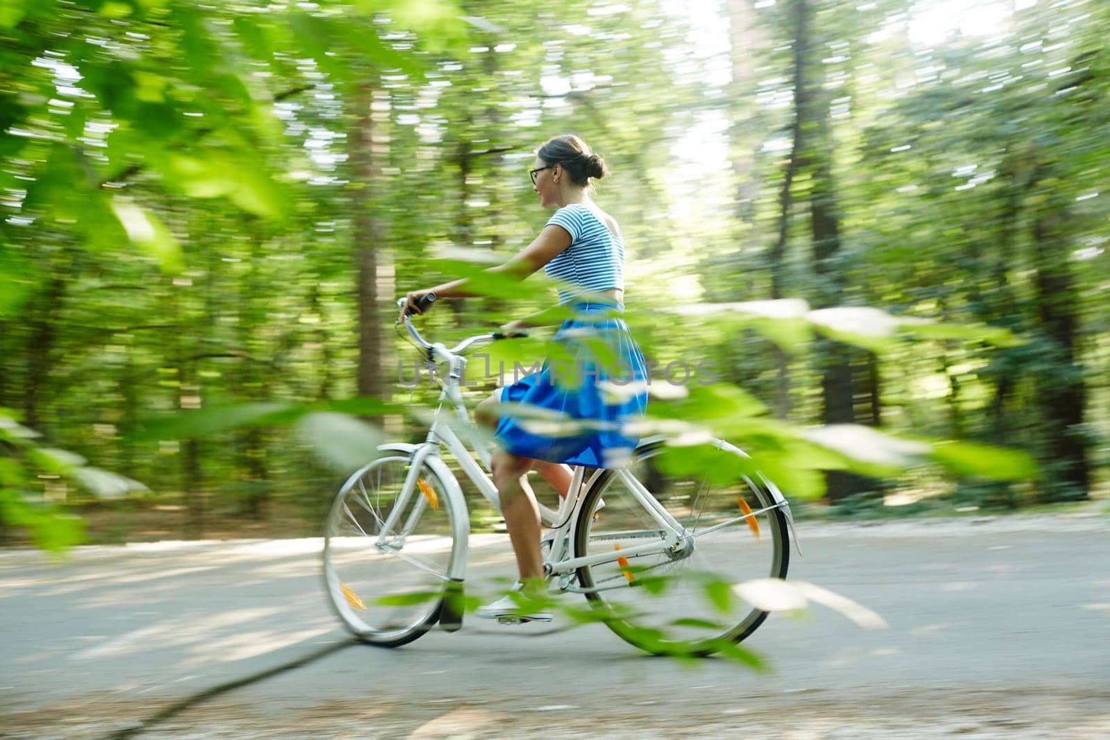 Modern girl riding bicycle in natural environment