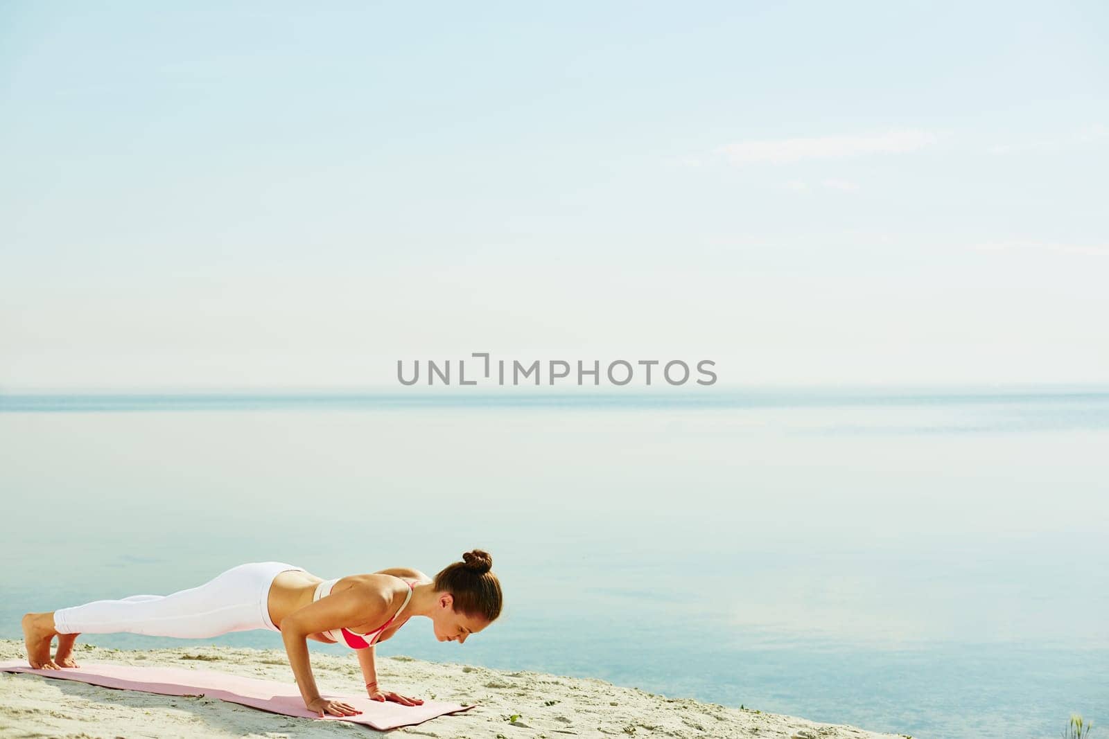 Fit woman doing pushups by the seaside