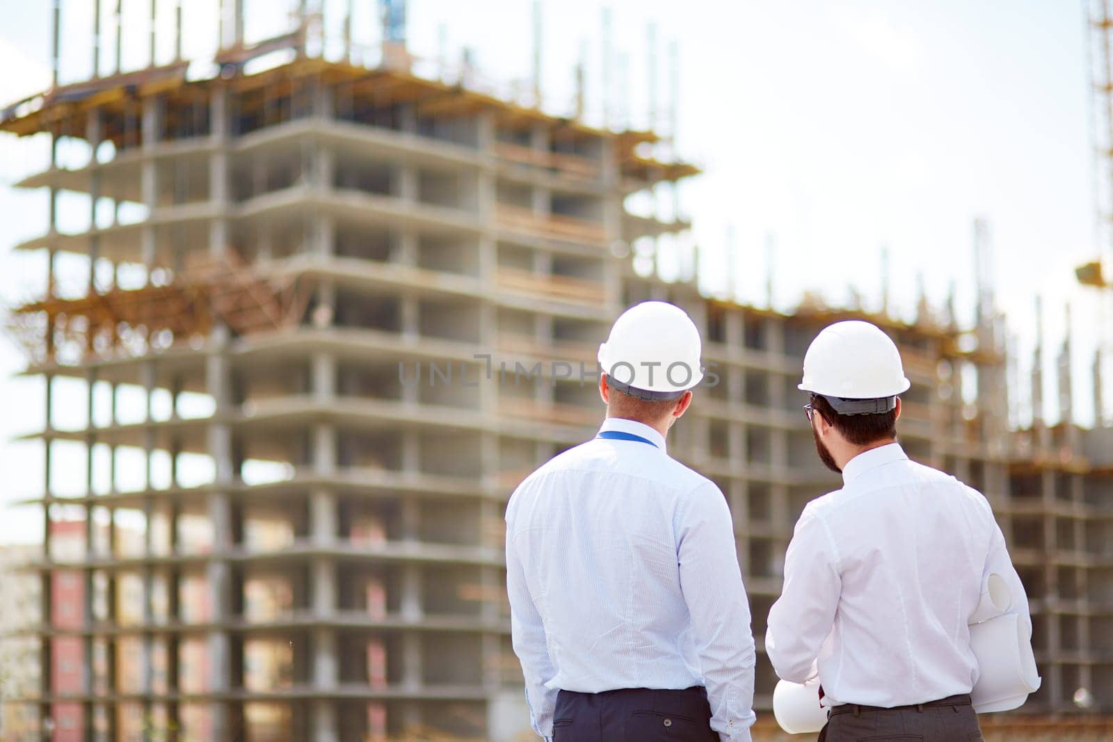 Male architects standing in front of new construction
