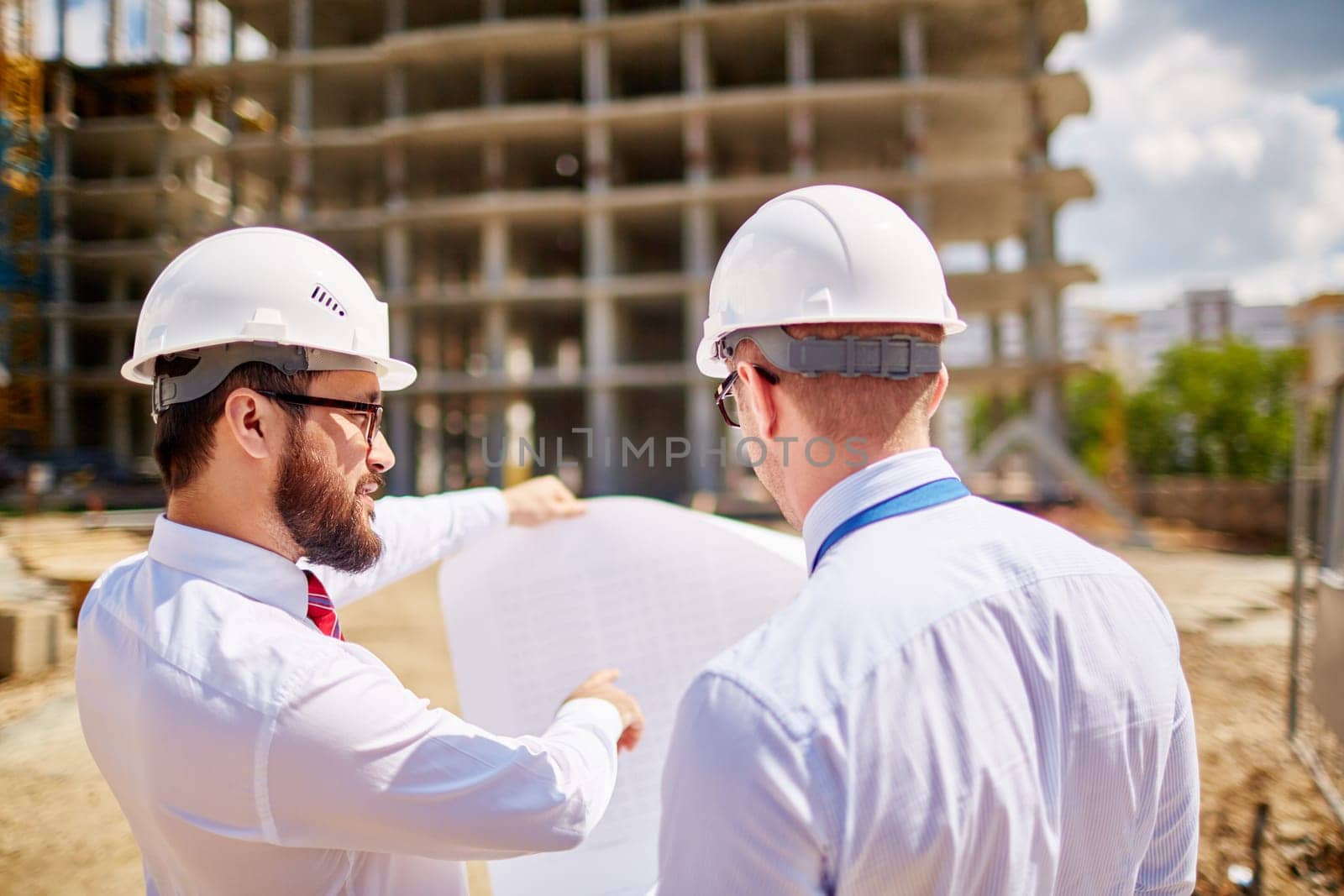 Young businessmen discussing sketch of new building