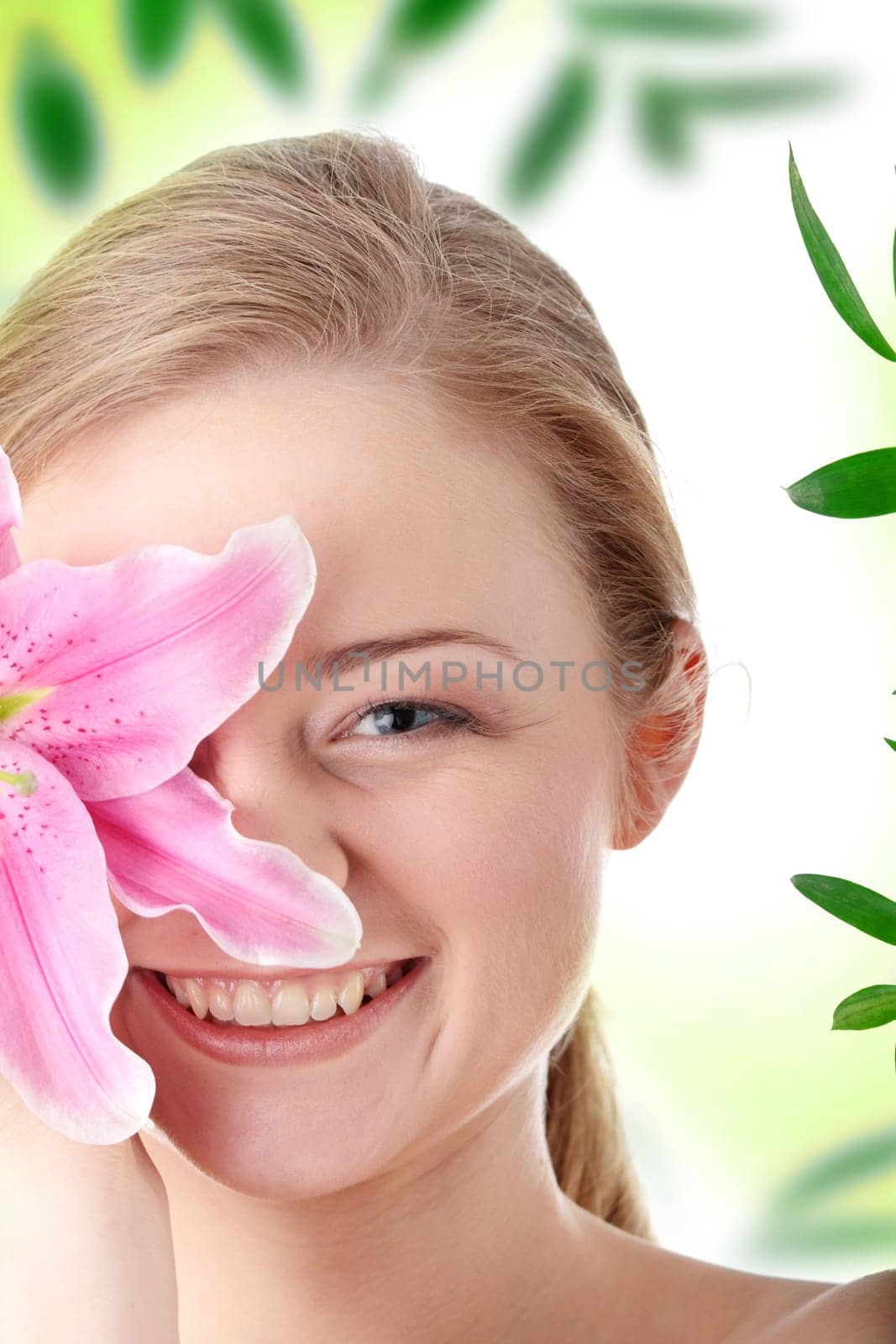 Portrait of young beautiful blond woman with lily flower