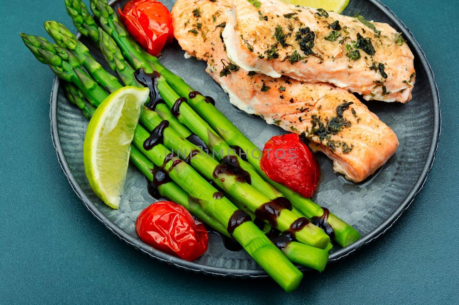 Grilled trout and green asparagus on a wooden table