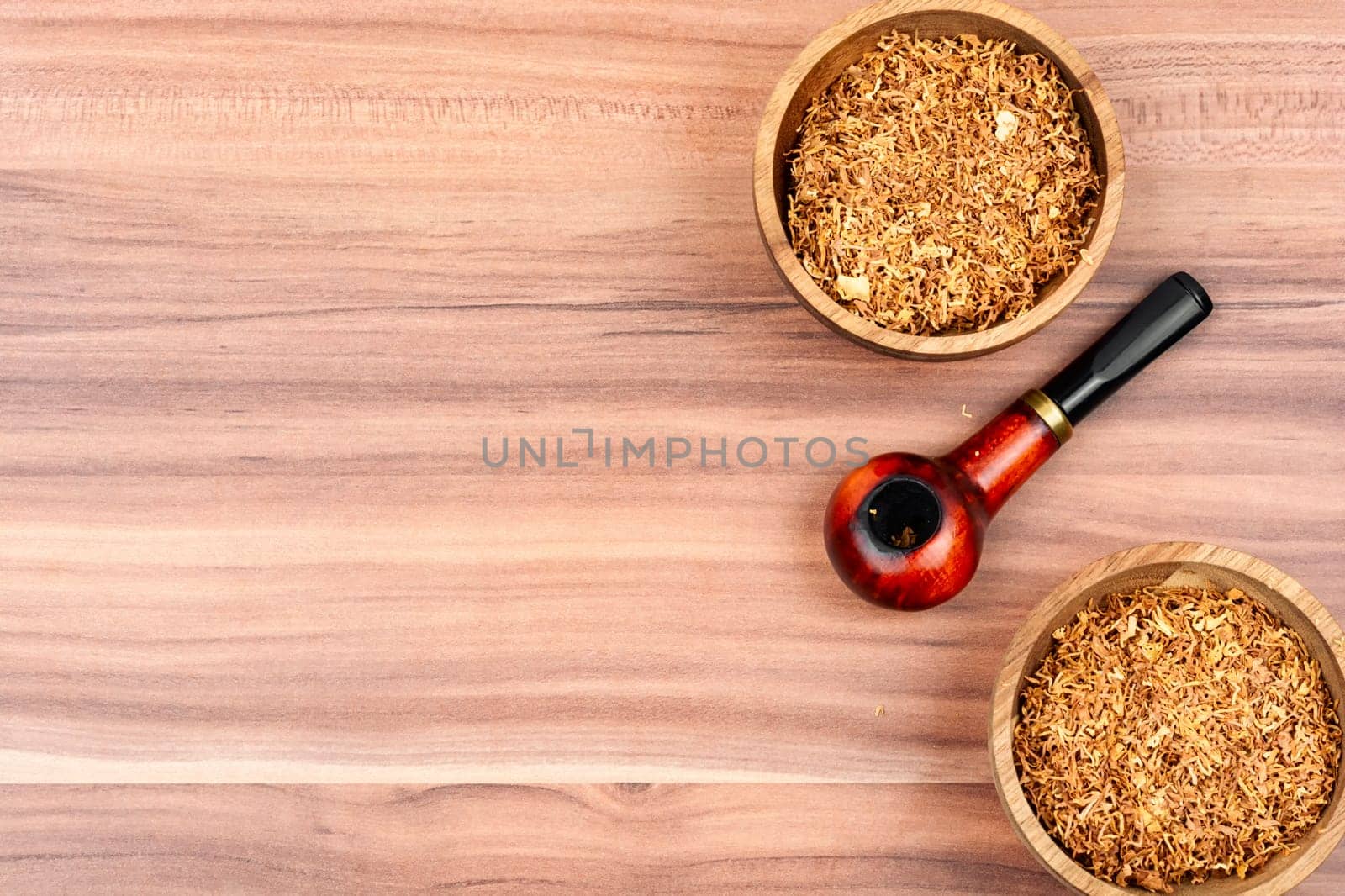 Fragrant smoking tobacco and a smoking tube or pipe on the table. Space for text