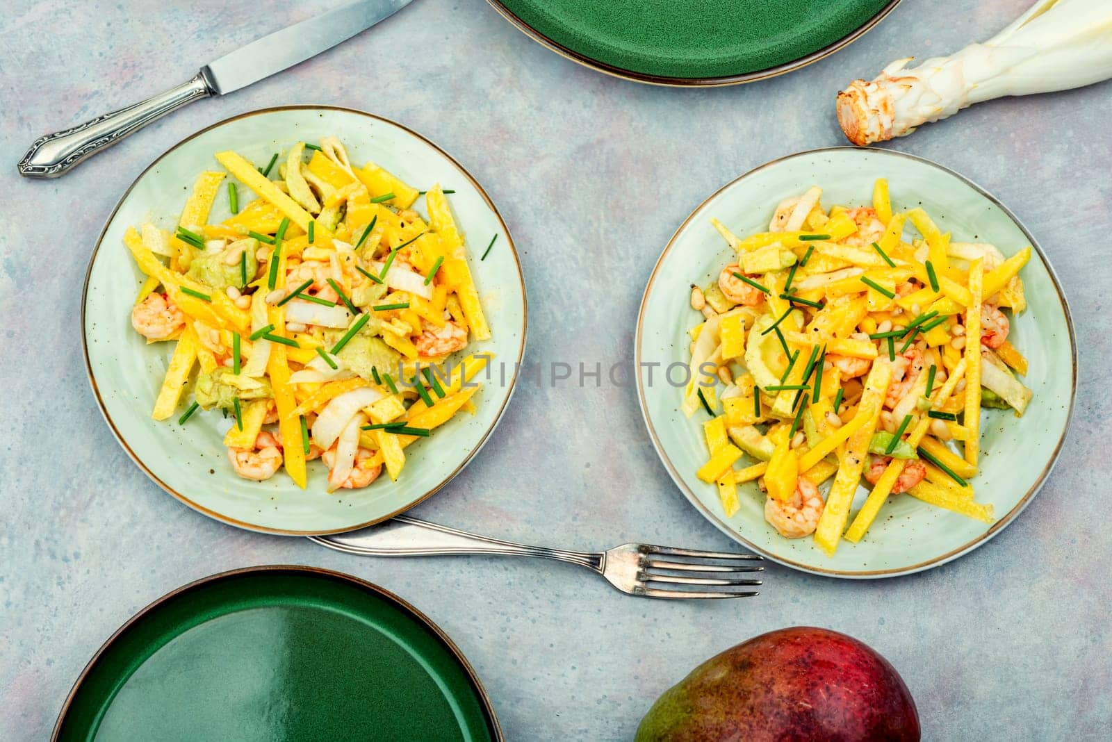 Dieting salad of mango, avocado, grilled shrimp and pine nuts.