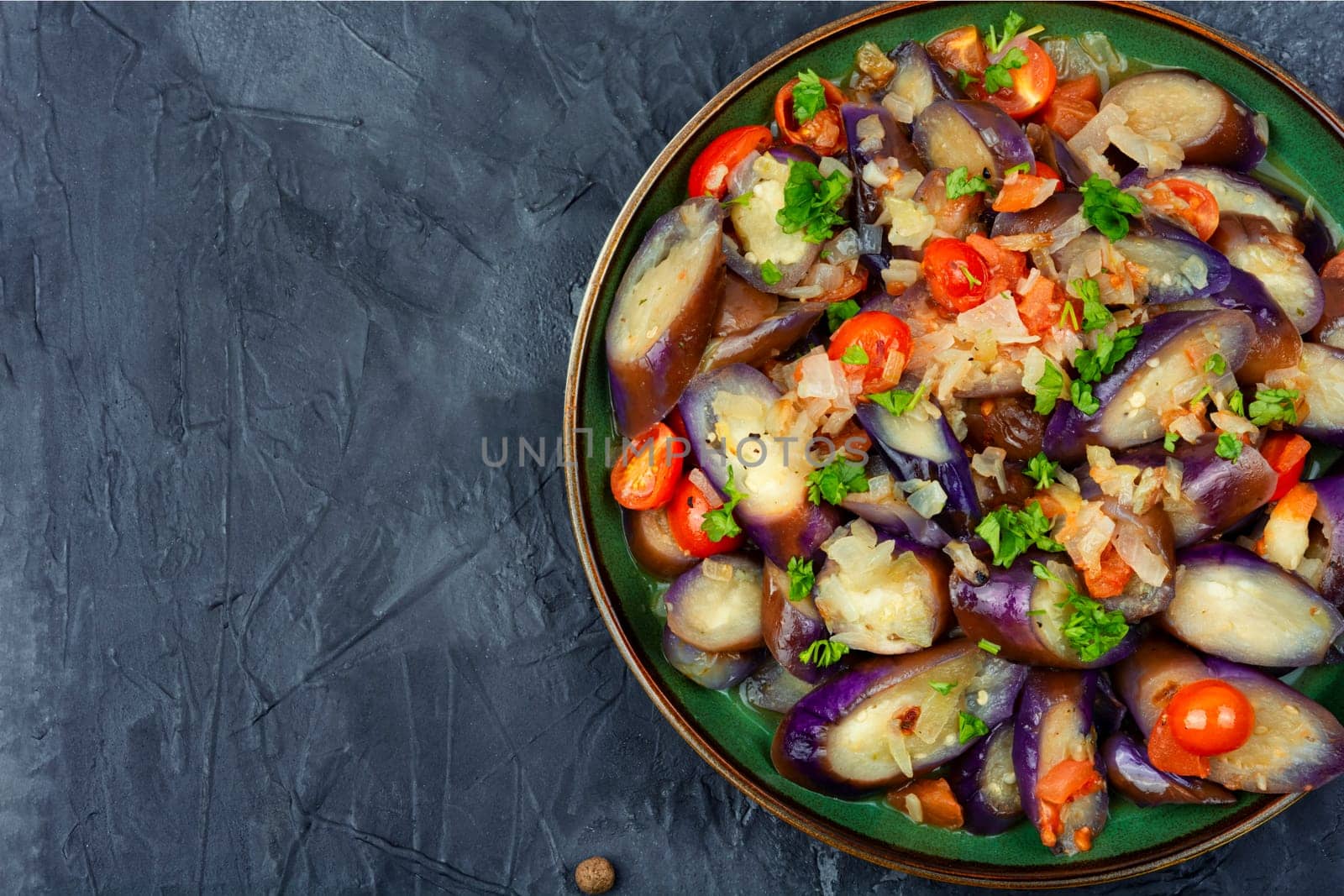 Warm purple eggplant, tomato and garlic salad. Copy space for text