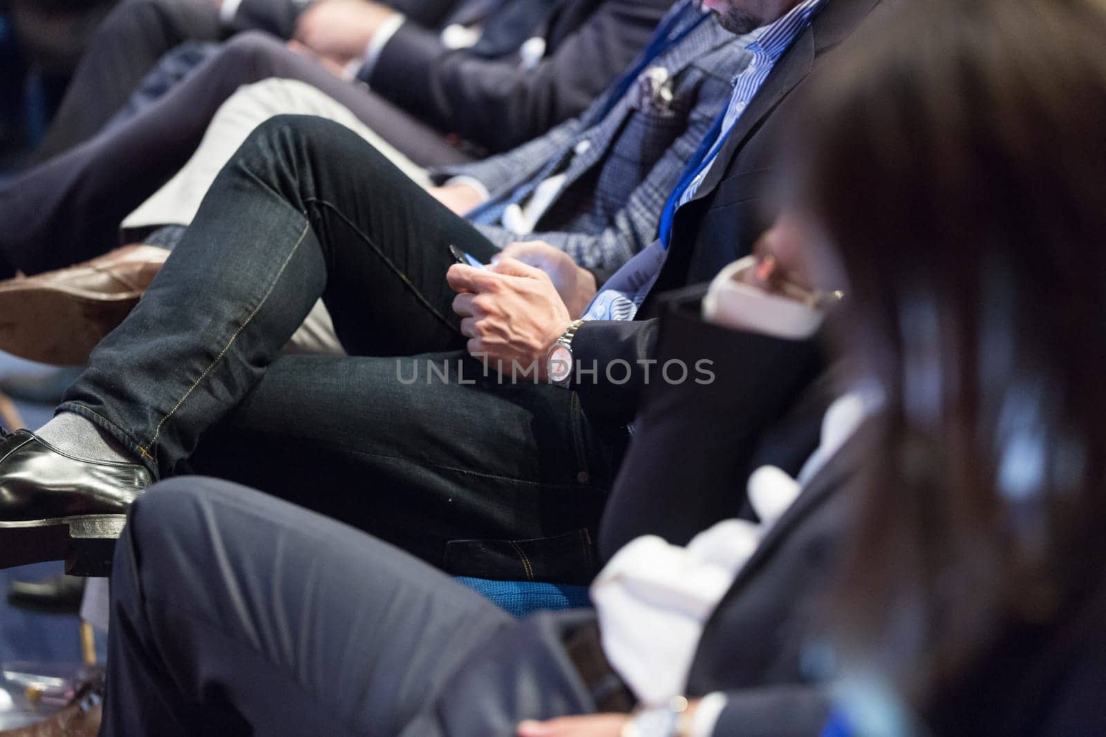 Row of unrecognizable business people sitting in conference hall at business event. Audience at business seminar. Business and Entrepreneurship concept.