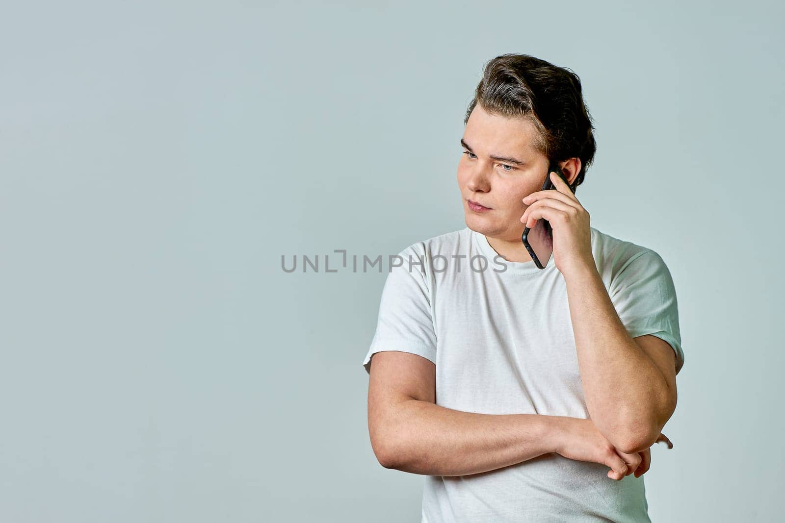 a man on a gray background is talking on the phone. High quality photo