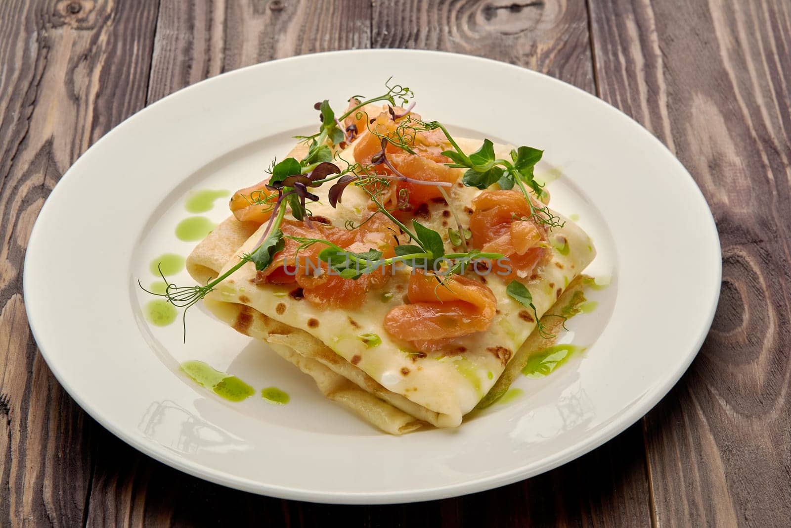 juicy pancakes with red fish on a white plate. High quality photo