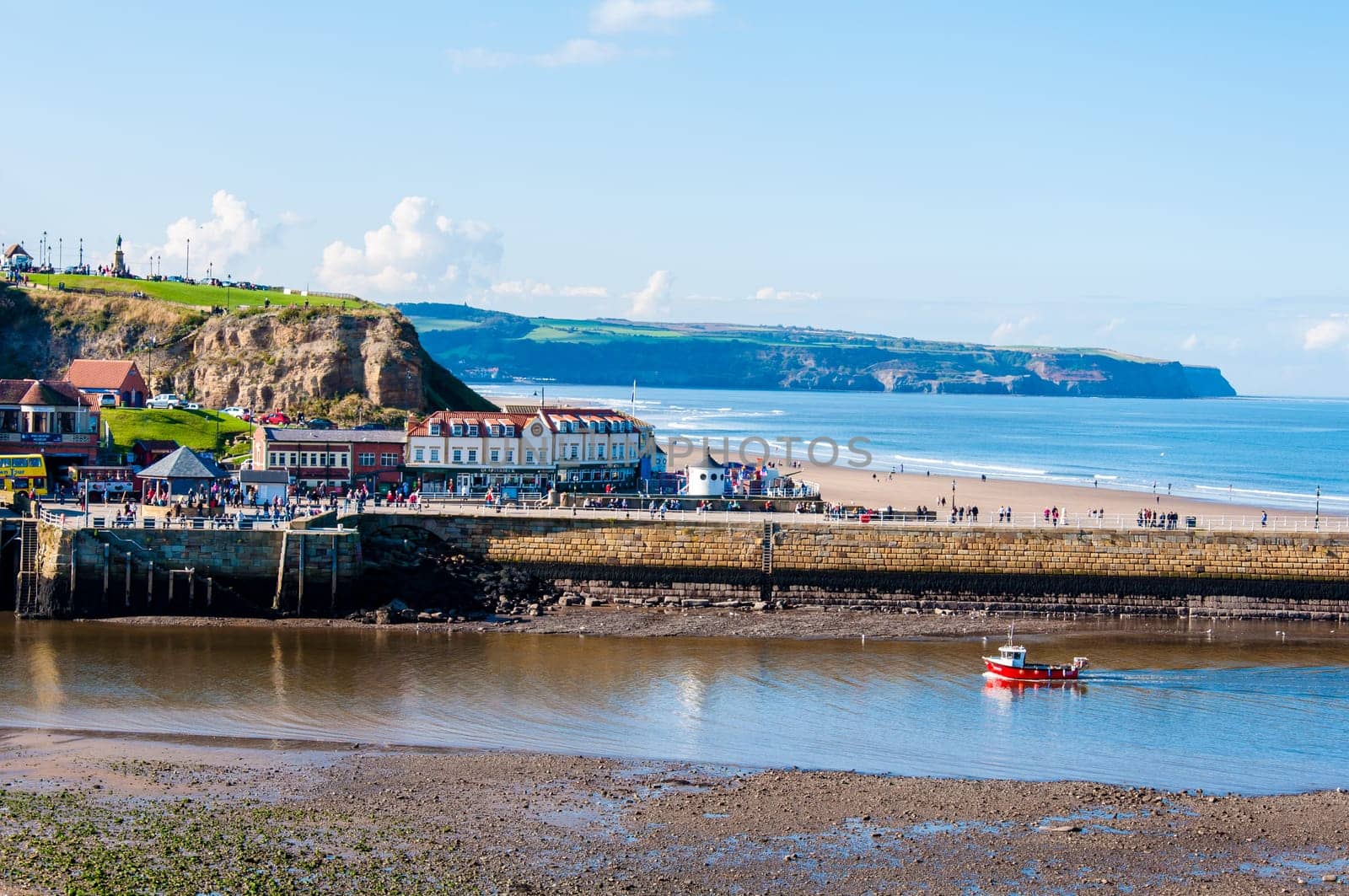 Scenic view of Whitby city and pier in sunny autumn day.Whitby is a seaside town and port in North Yorkshire, UK. Its attraction as a tourist destination is enhanced by its association with the world famous horror novel Dracula, written by Bram Stoker