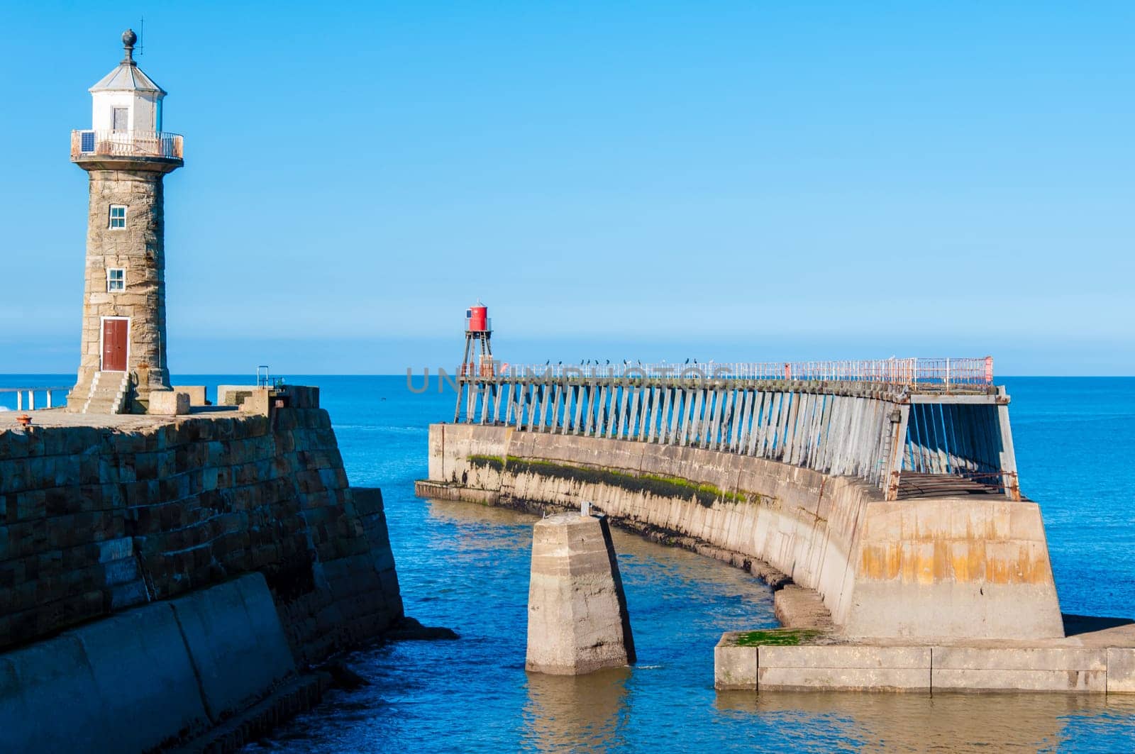 Scenic view of Whitby Pier in sunny autumn day.Whitby's attraction as a tourist destination is enhanced by its association with the world famous horror novel Dracula, written by Bram Stoker