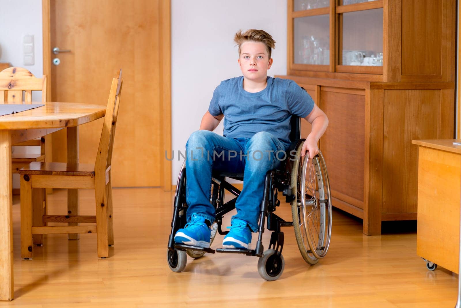 disabled boy in wheelchair at home in the living room