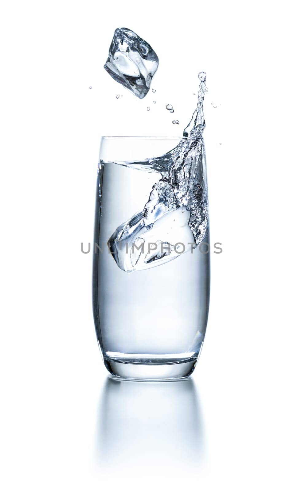 Water glass with ice cubes and splashes