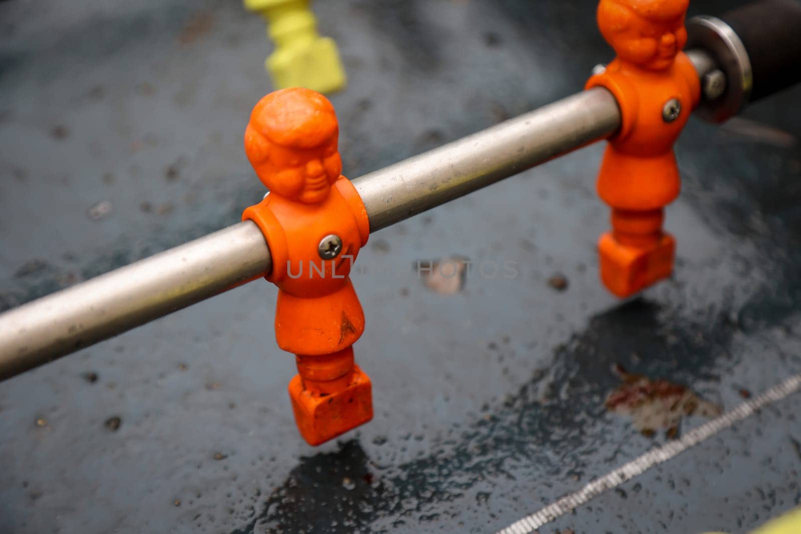 Figures of a table football game in close-up. The figures have a side parted hairstyle.