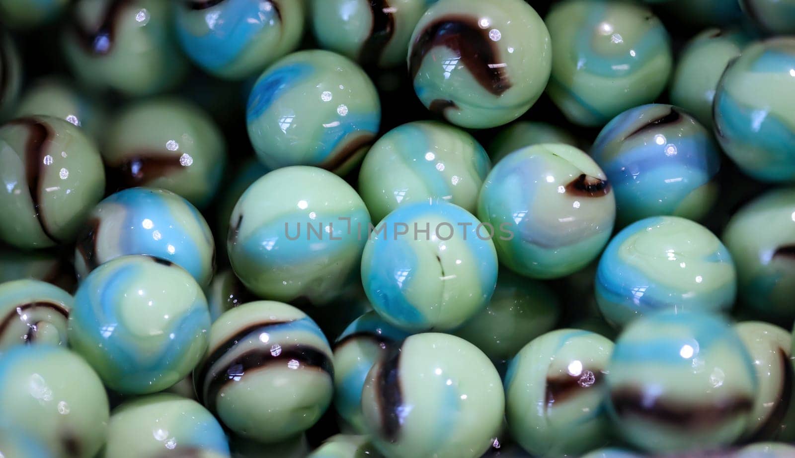 Close-up of many coloured glass beads in a container.