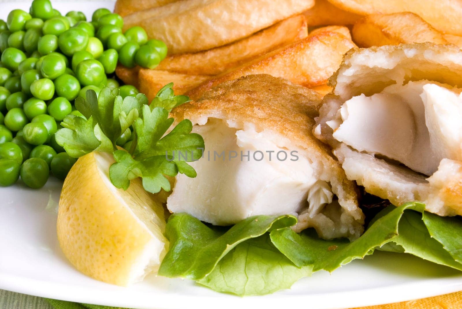 Fried fish and chips with lemon and peas