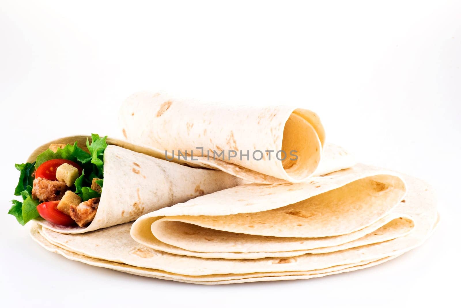 Tortilla filled with lettuce chicken tomatoes and cucumber with plain tortillas