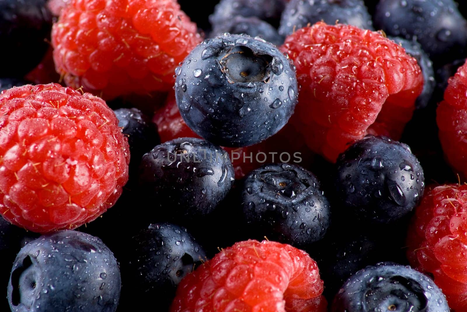 Closeup of fresh blueberries and raspberries mixed toghether
