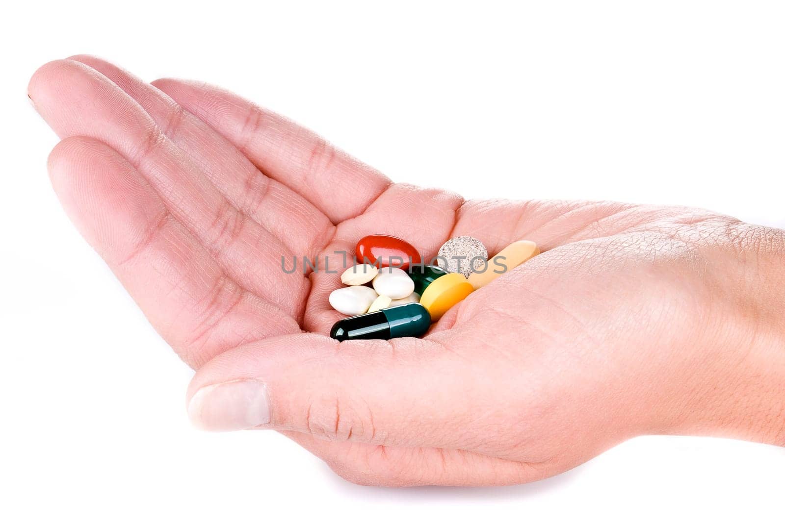 hand with various pills over white background