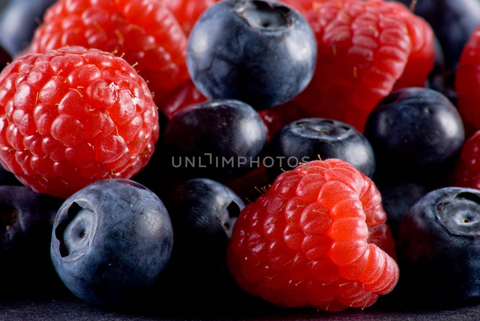 Closeup of fresh blueberries and raspberries mixed toghether