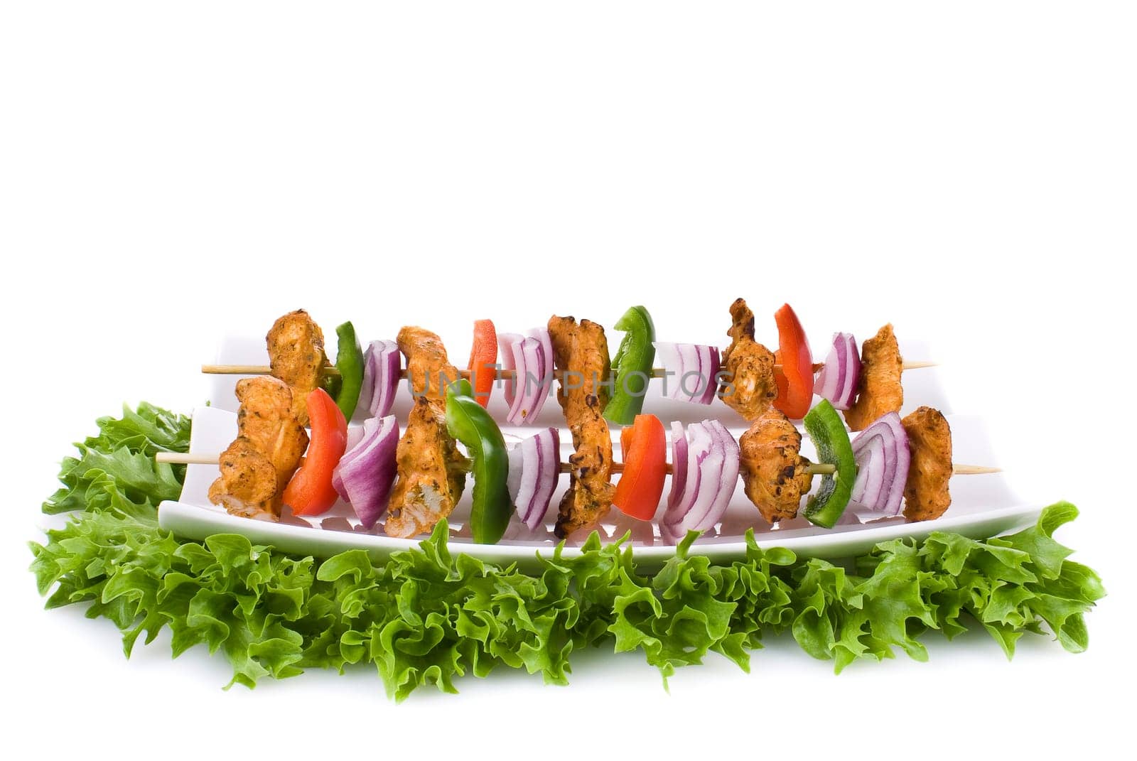 Skewers with chicken and vegetables on the plate - isolated