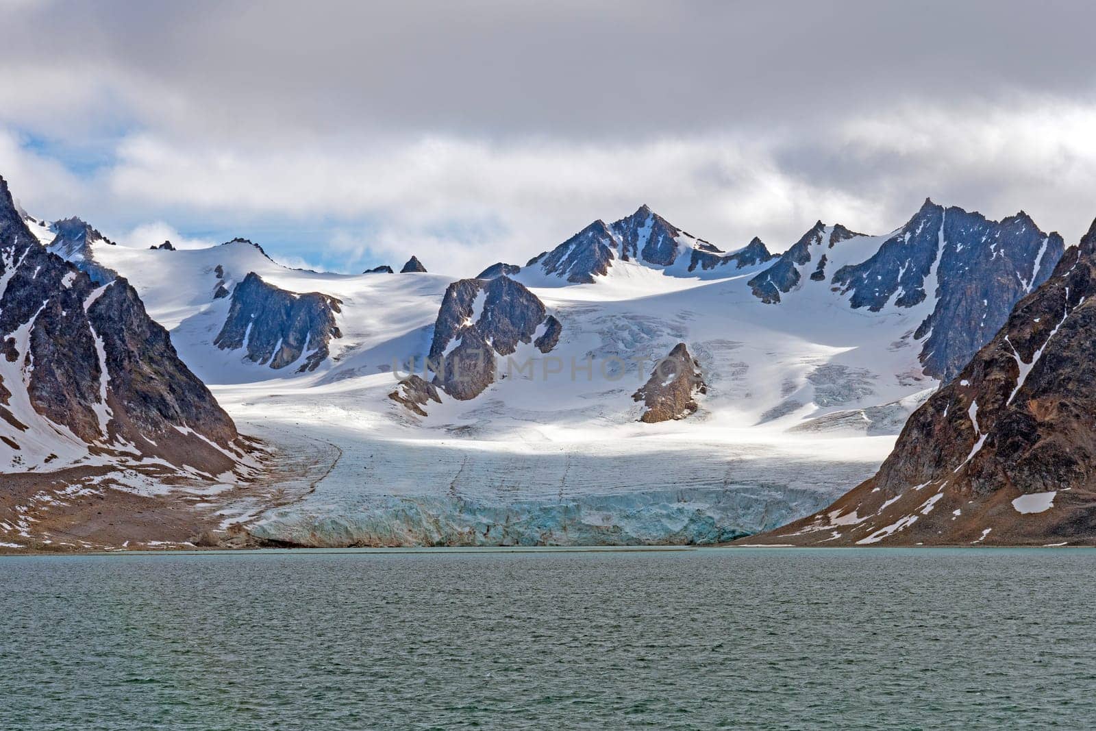 Tidal Glacier and Snowy Mountains in the High Arctic in the Svalbard Islands in Norway