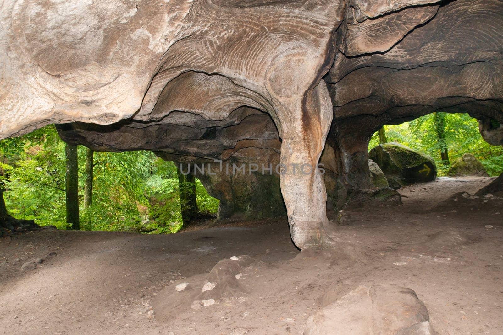 Huel Lee or Hohllay on the Mullerthal trail in Luxembourg, open cave with view to the forest, sandstone rock formation