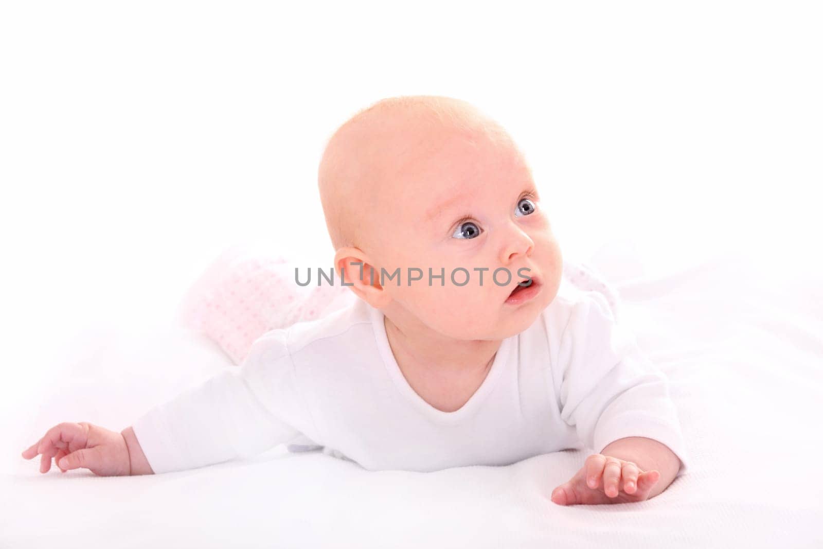 A picture of a nice small baby girl looking with curiosity over white background