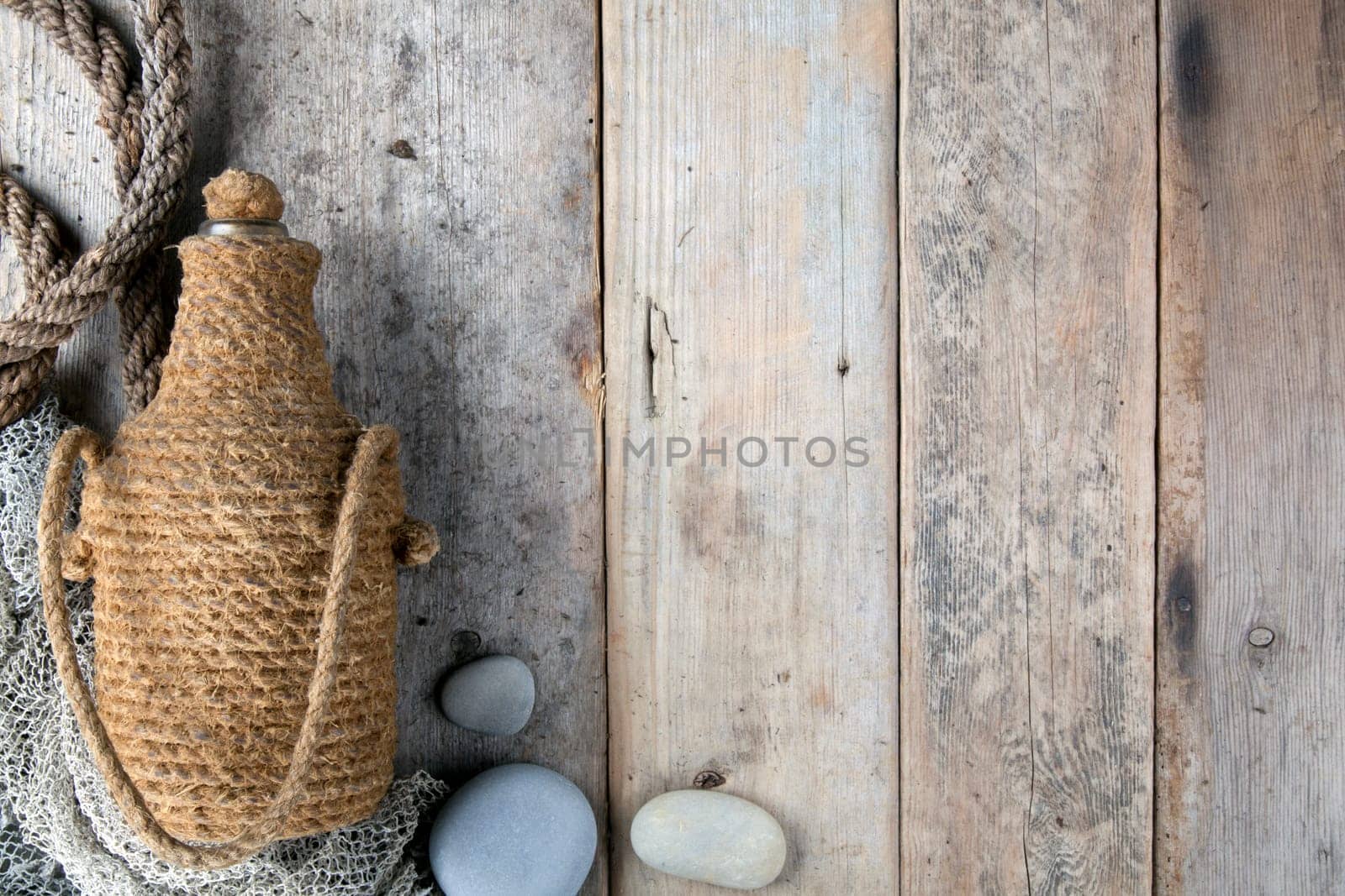 Bottle covered by tar rope with wooden background
