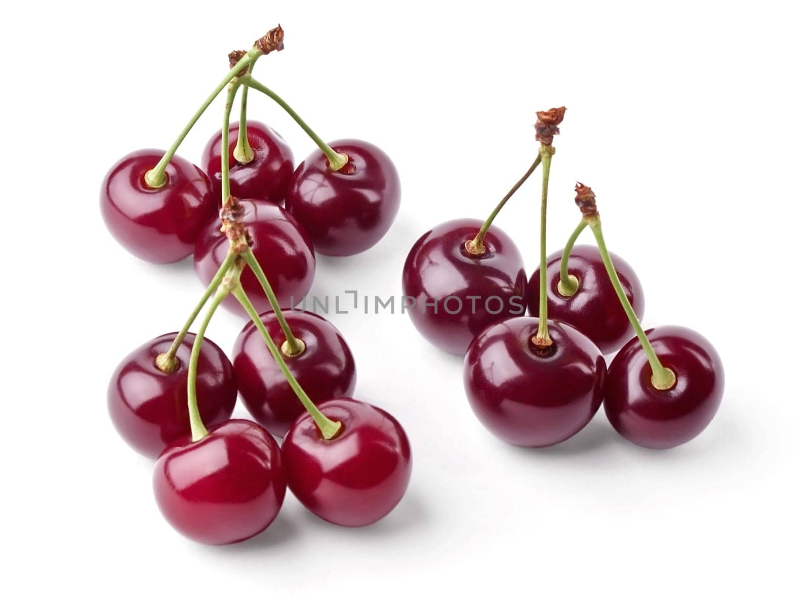 Three groups of juicy cherries view from top on white background