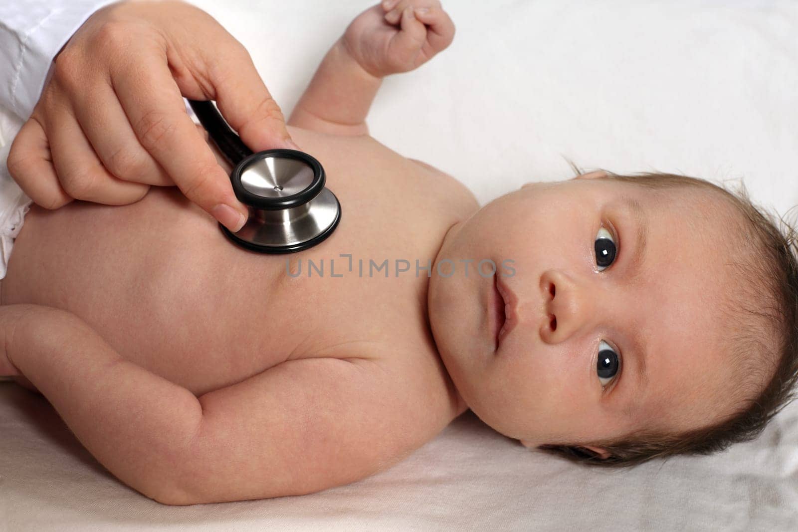 Photo of a doctor checking a baby's heartbeat with a stethoscope.