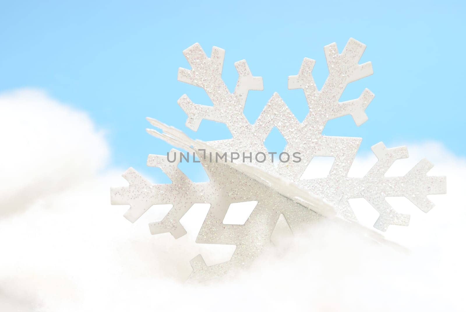A white snowflake ornament on a white and blue background.