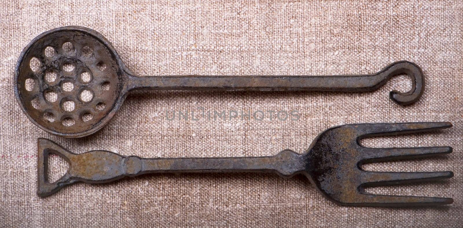 Ancient metal tableware lie on a canvas