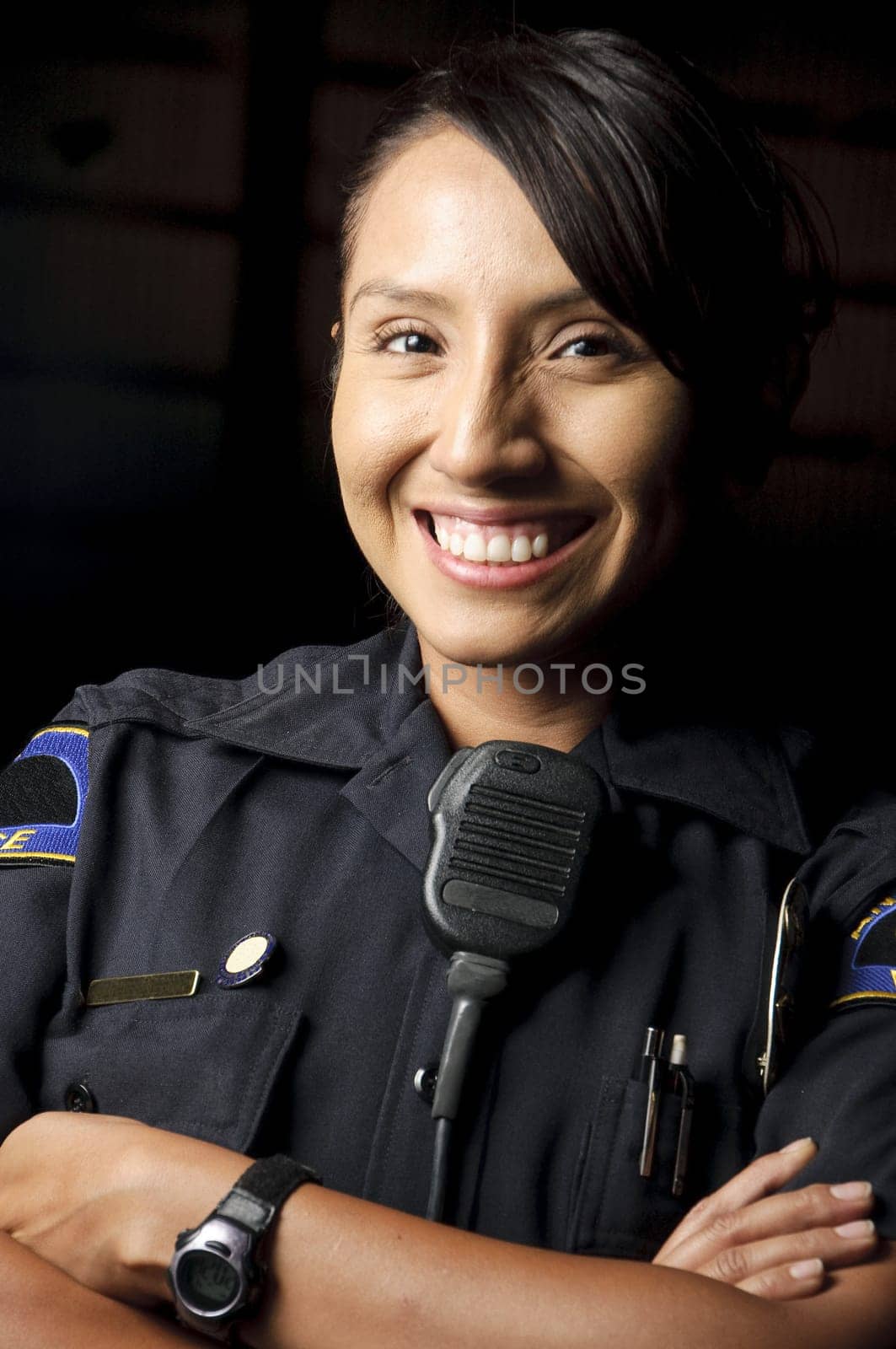 a female police officer smiling at night and posing for her portrait.