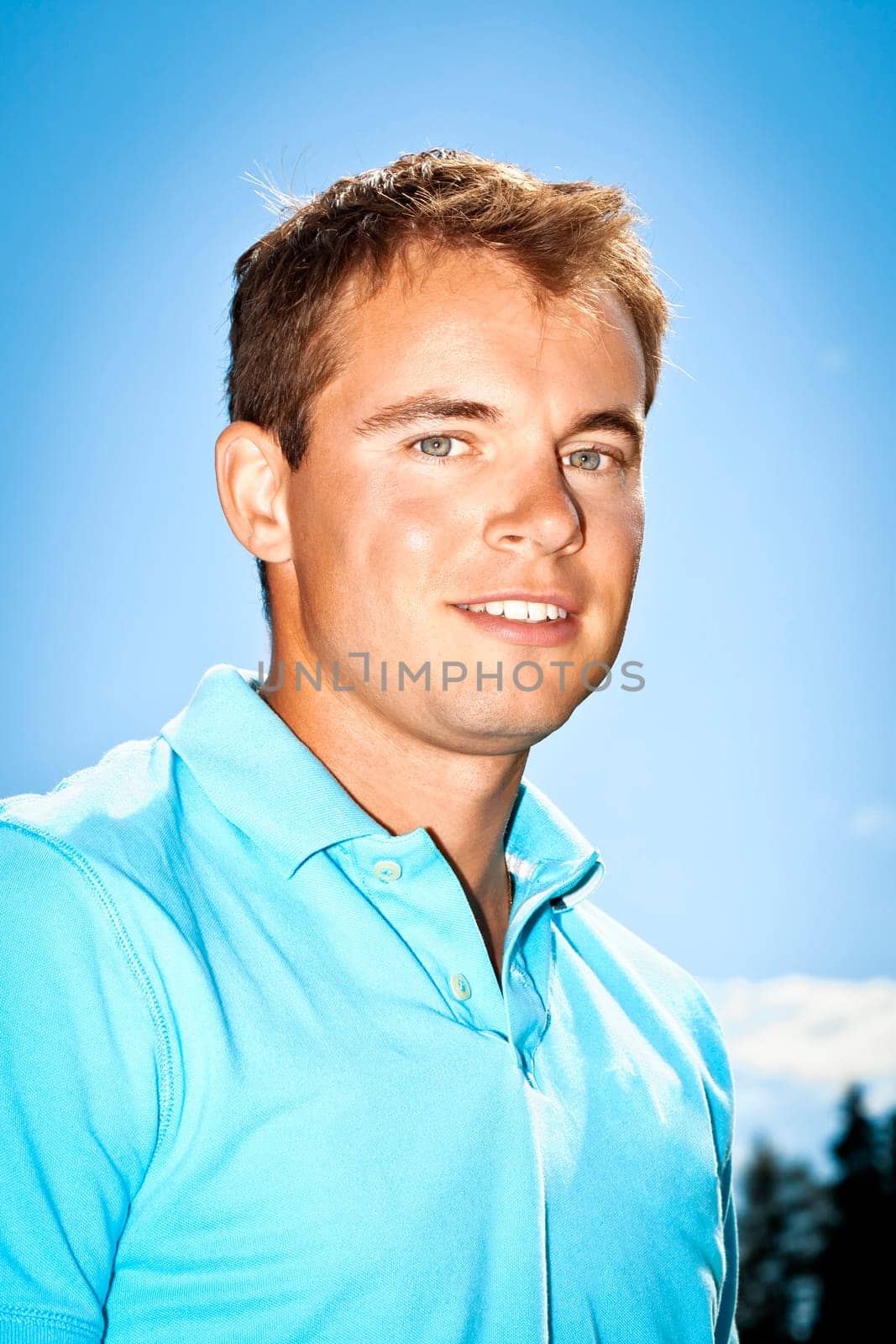 A handsome young man in front of the blue sky