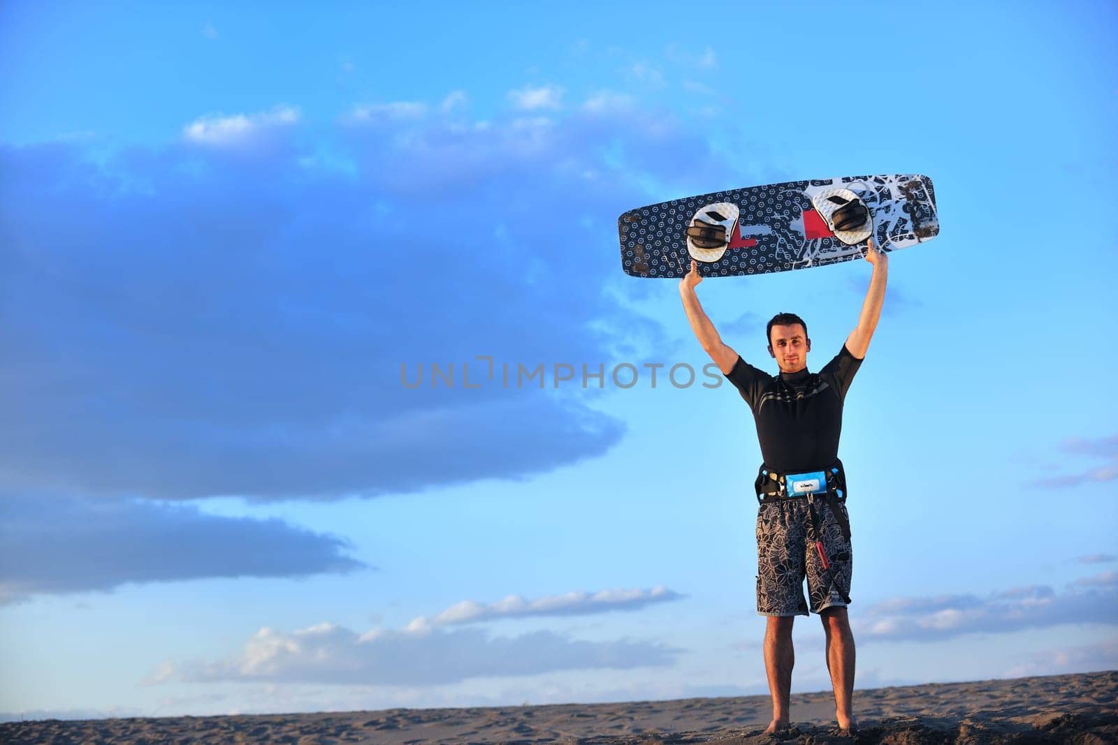 Portrait of a strong young  surf  man at beach on sunset in a contemplative mood with a surfboard