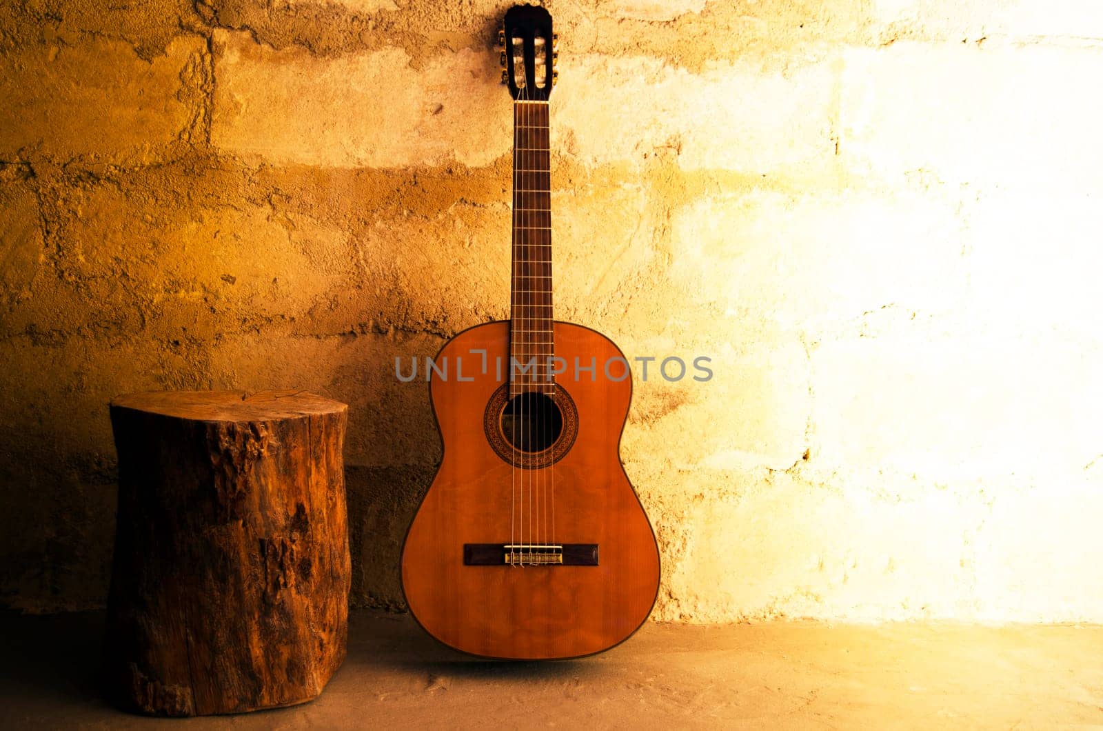 Acoustic guitar on old wall and stump with copyspace