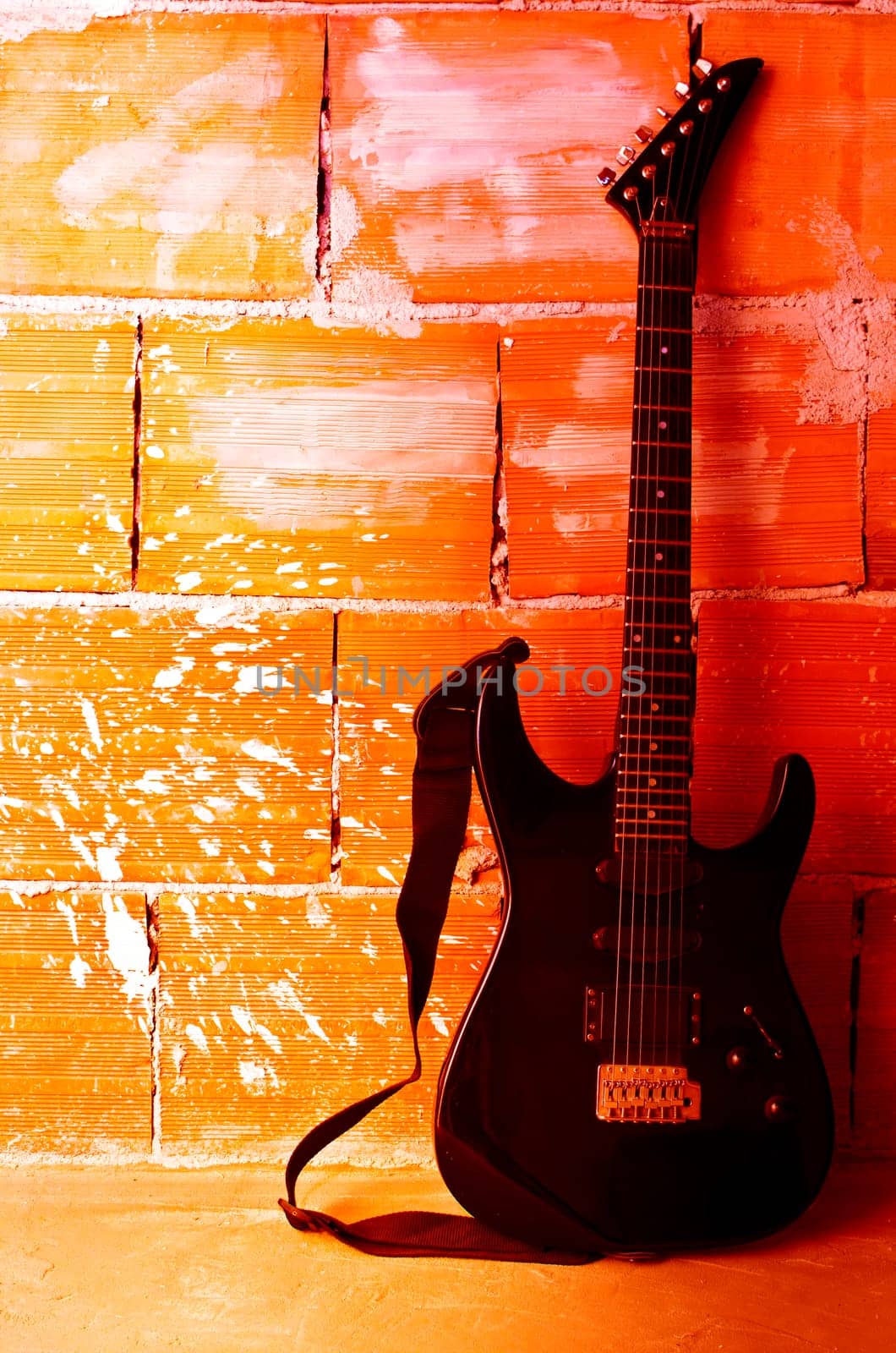 Electric guitar on old wall and stump with copyspace