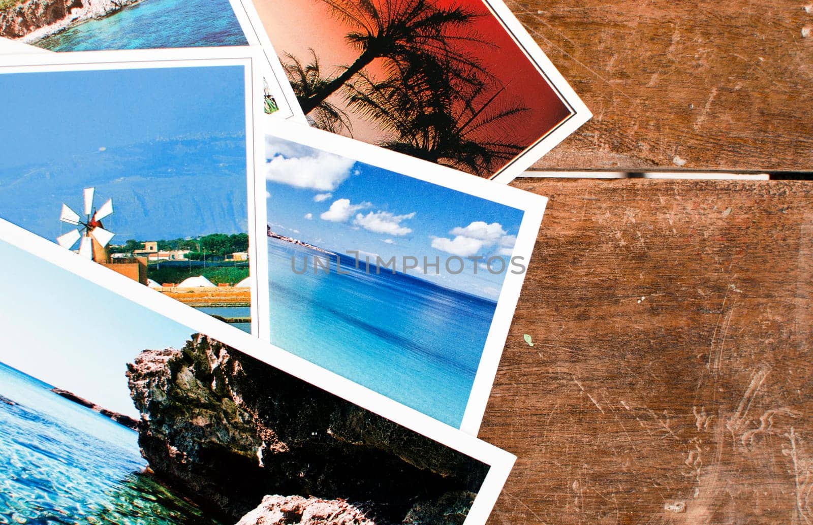 Pile of postcards - or photos - over an old wooden table