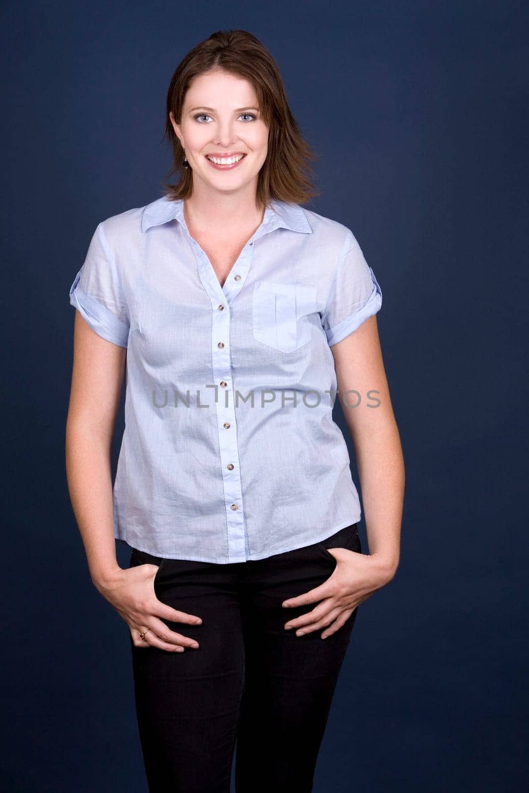pretty casual brunette wearing blue top on dark background