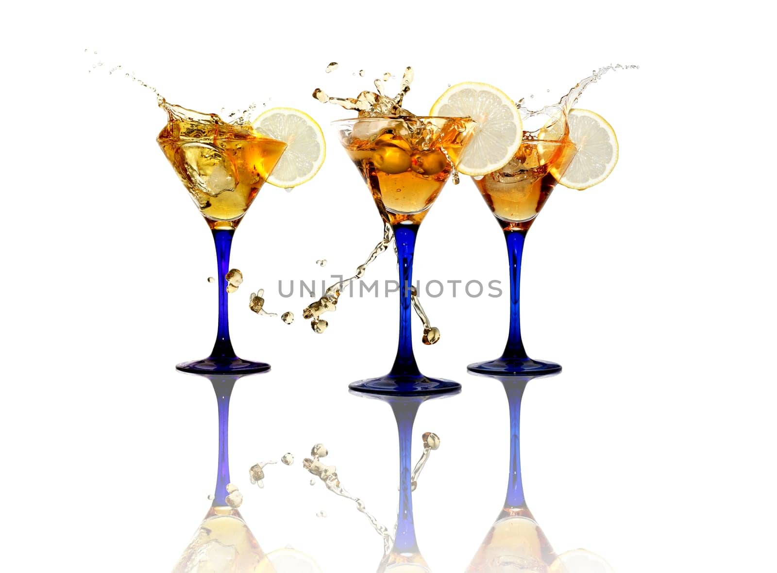 Three wineglasses with splashing beverage and lemon on white background. Isolated with clipping path
