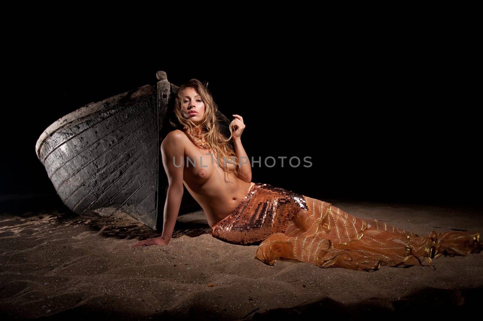 woman in exotic dress standing on a boat on the beach