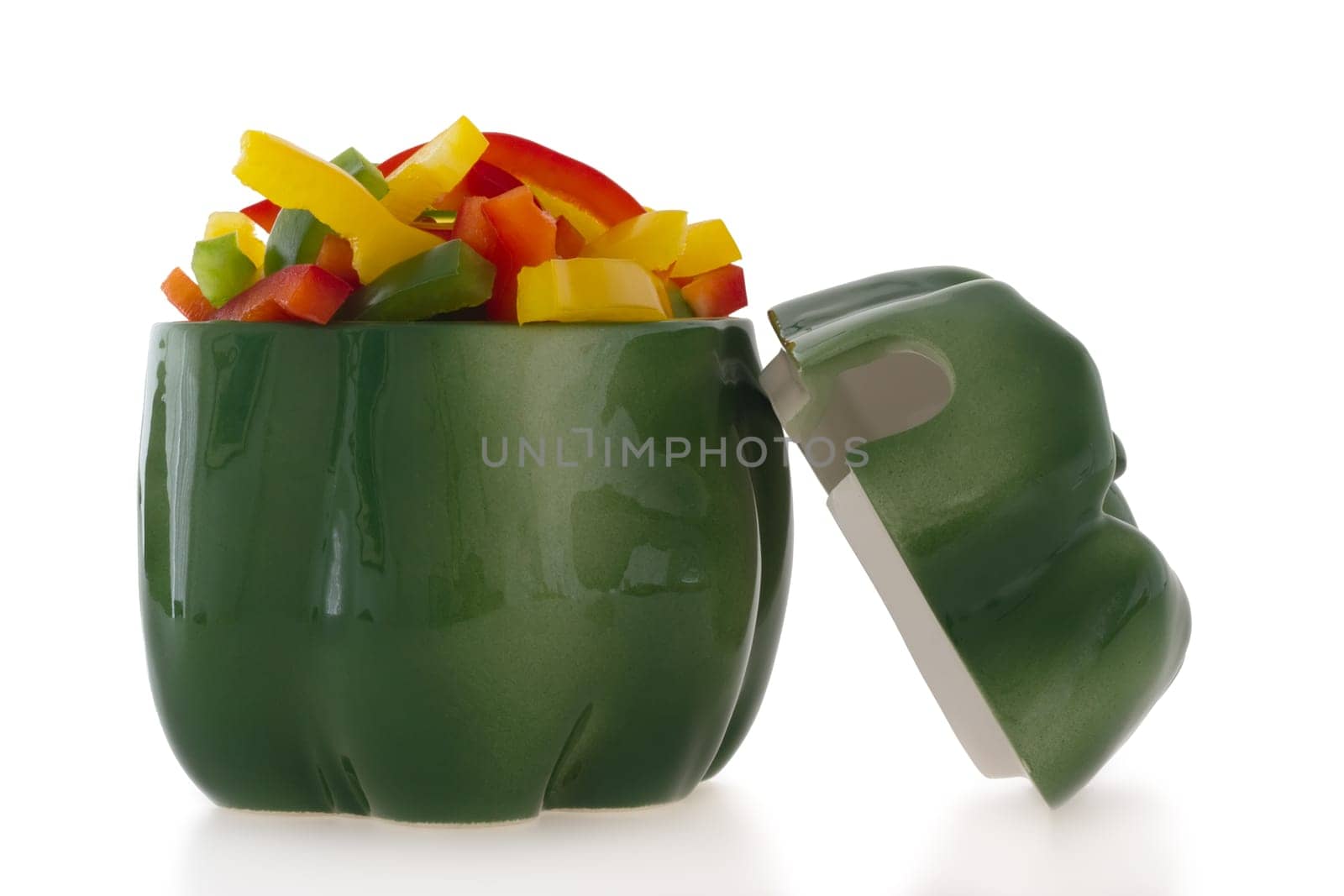 Ceramic green pepper shaped ornament filled with cut colofrul bell pepper slices.