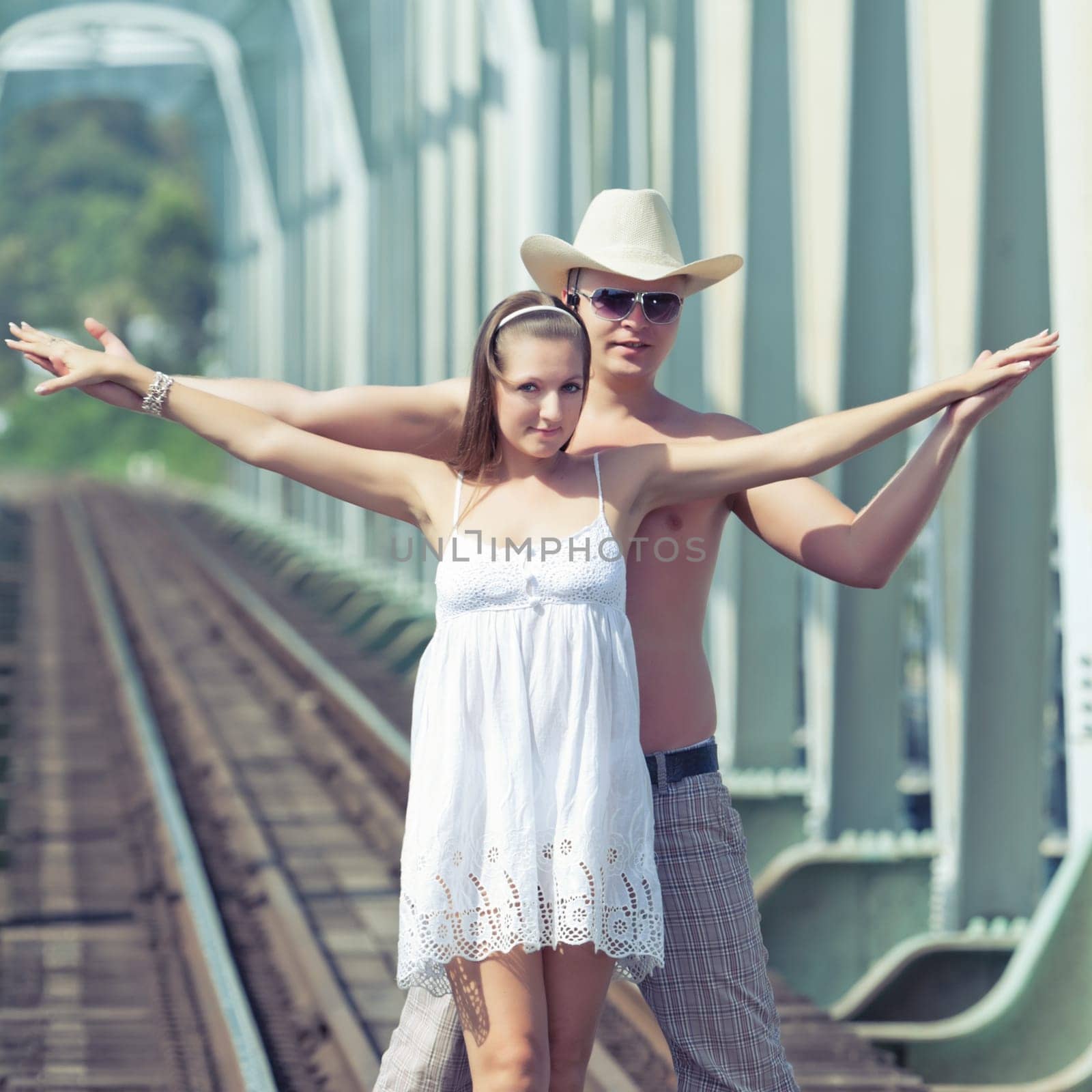 Young couple posing on a train tracks
