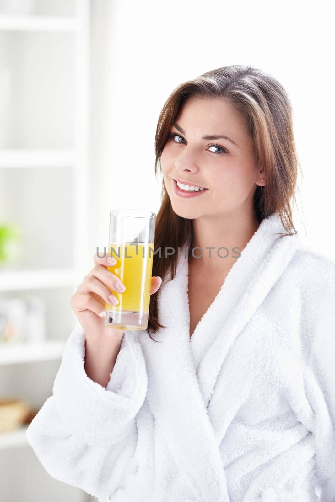 Beautiful girl in a bathrobe with a glass of juice