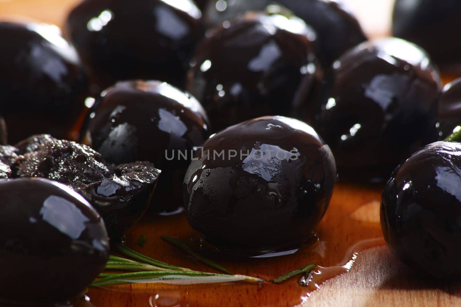 Black olives close up on a wooden table