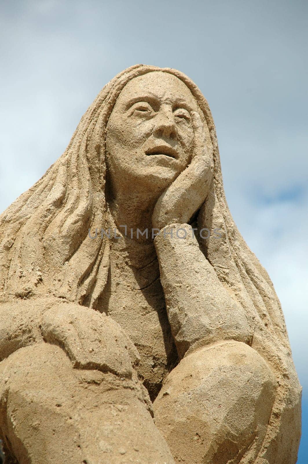 Sand sculpture of a sad woman.