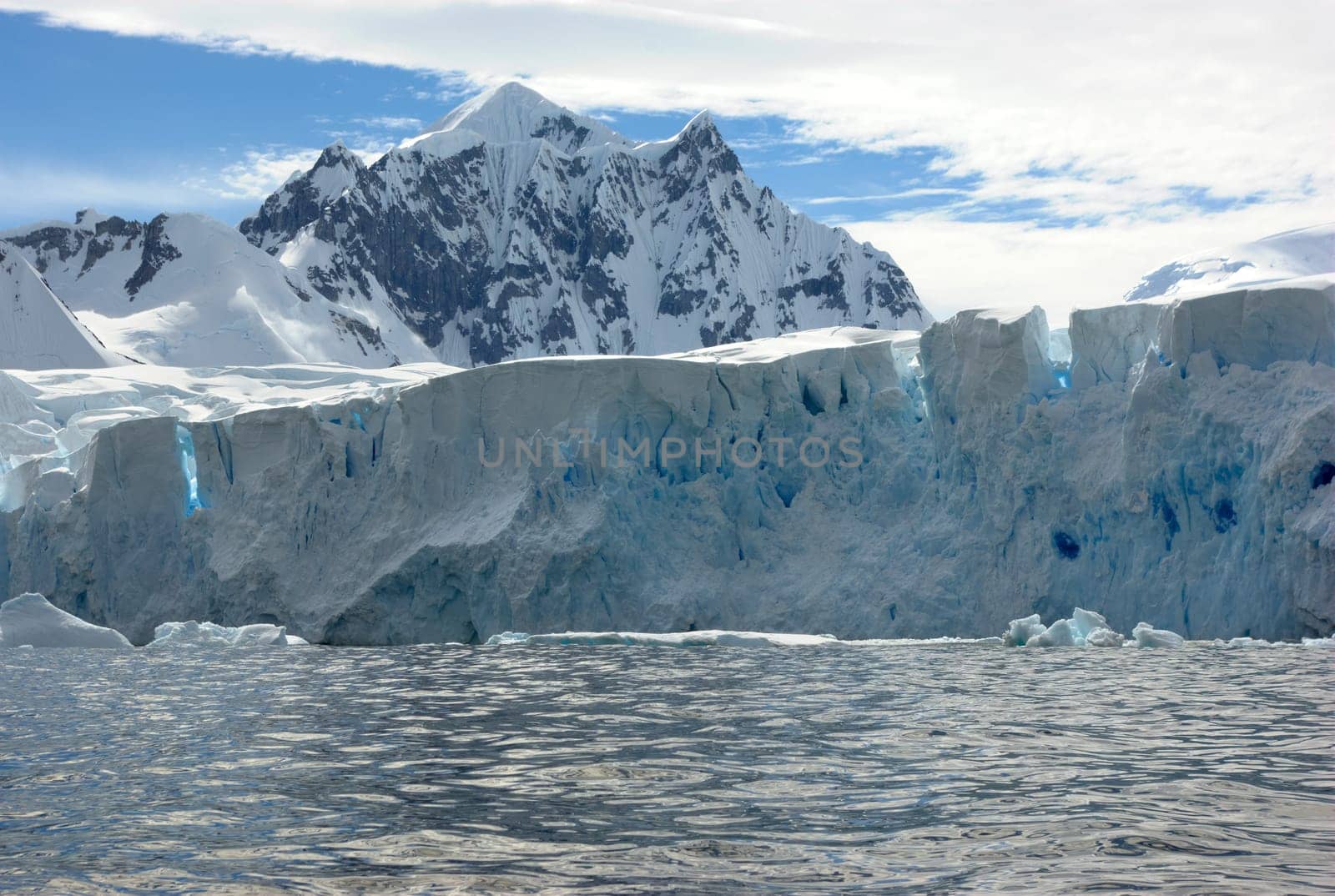 Huge iceberg in Antarctica, blue sky, azure water, sunny day.